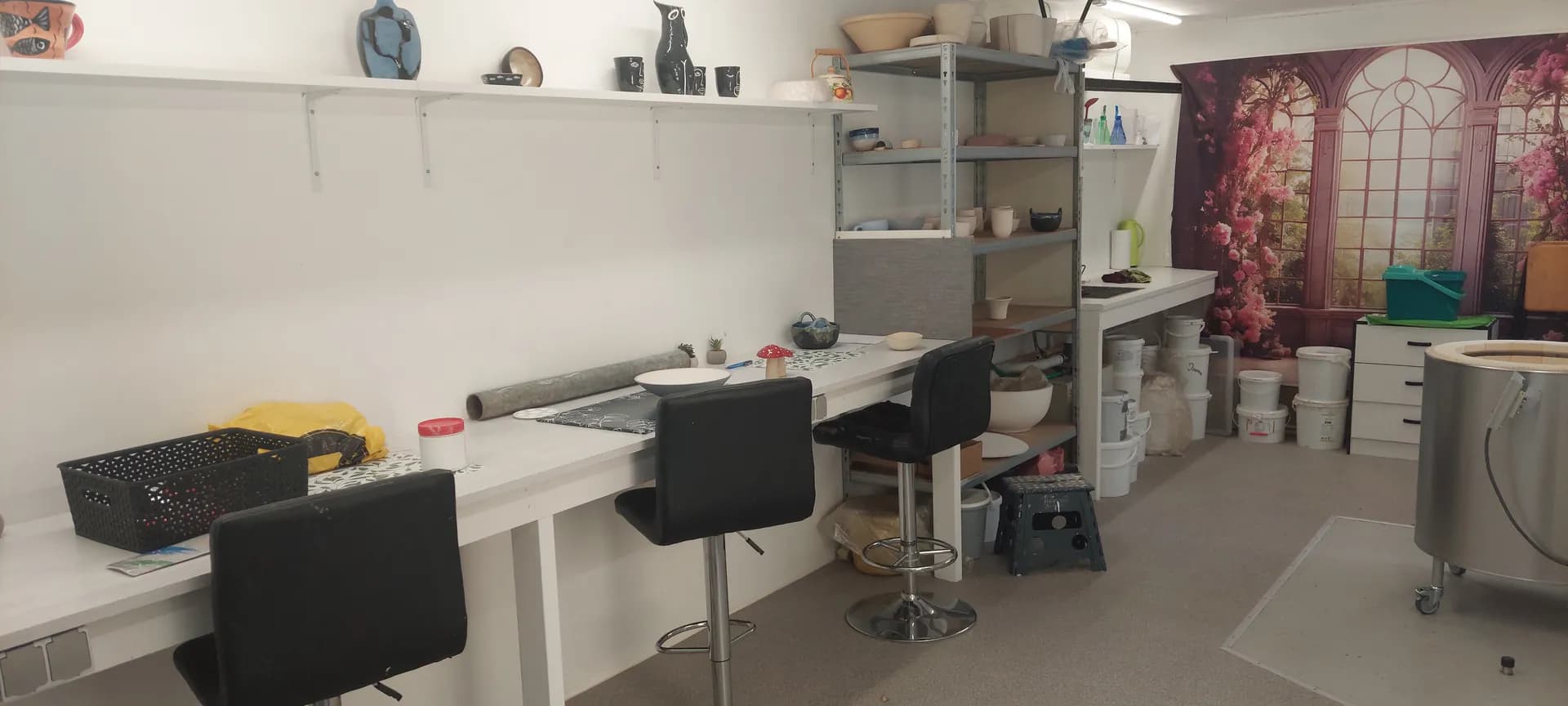 Værkstedet i Veksø med borde, stole og hylder fulde af keramik
